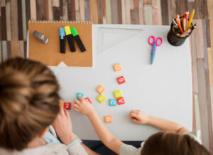 Criança e tutor aprendendo sobre letras e números